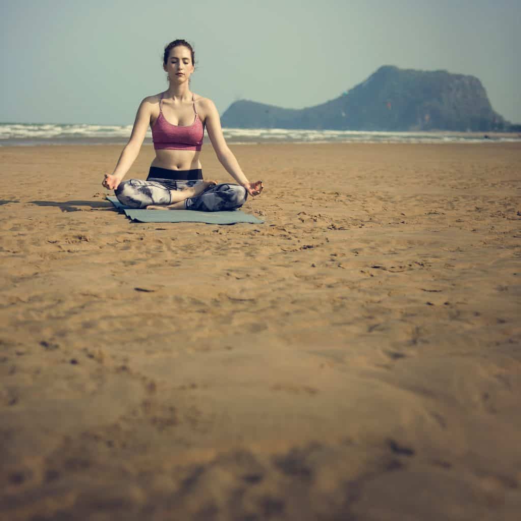 Femme sur la plage en méditation pleine conscience